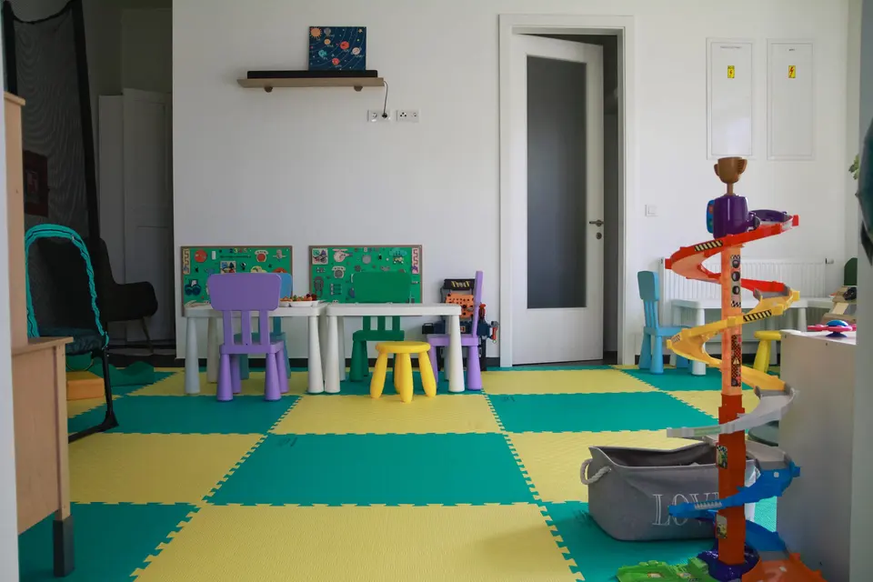Prostor za igru sa šarenim podlogama, dječjim stolovima i stazom za autiće