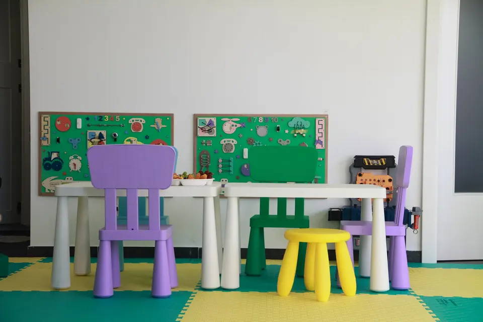 Kutak s dječjim stolovima i edukativnim pločama